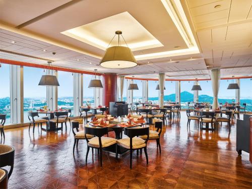 a dining room with tables and chairs and windows at InterContinental Nanjing by IHG in Nanjing