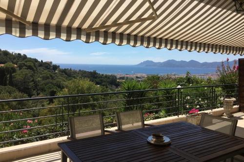 un tavolo e sedie su un balcone con vista di Sea View & Large Terrace LIVE IN LA VISTA a Cannes