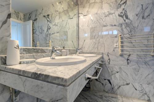 ein Marmorbad mit einem Waschbecken und einem Spiegel in der Unterkunft Bright Nordic style penthouse in beachside resort in Marbella