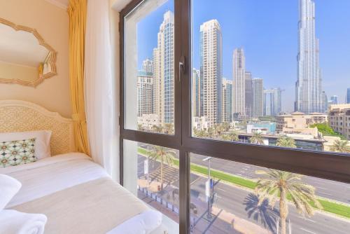 a bedroom with a window with a view of the city at Ultra Luxury Downtown - Full Burj Khalifa View - 5 Min Walk To Dubai Mall! in Dubai