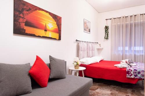 ナポリにあるCentral Station Guest Houseのベッドルーム(赤いベッド1台、ソファ付)