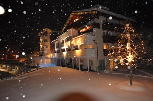 a building in the snow at night at Hotel Alpina Wellness & Spa Resort in Kössen