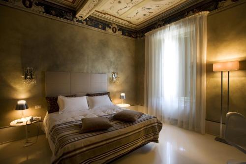 a bedroom with a bed with two lamps and a window at Palazzo Bontadosi Hotel & Spa in Montefalco