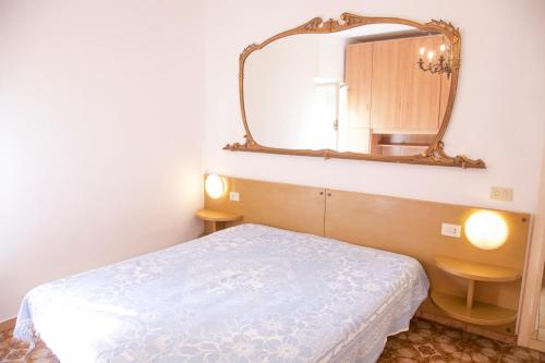 a bedroom with a bed and a mirror on the wall at Loft Seccheto sul Mare in Seccheto