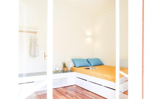 a small bedroom with a bed in a white wall at ViLLaRa: Style, Hospitality & Design (City Center) in Athens