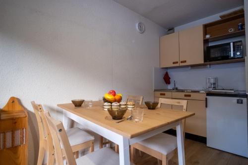 kuchnia z drewnianym stołem z owocami w obiekcie Charming studio with beautiful view - Huez - Welkeys w mieście LʼHuez