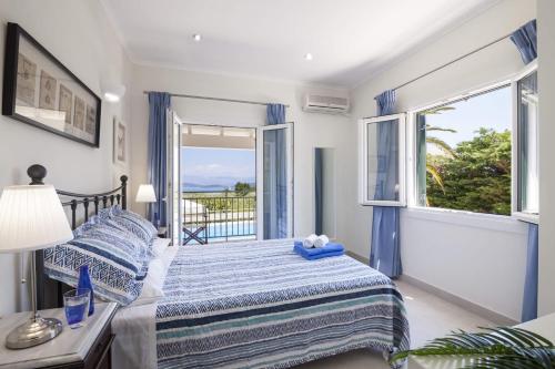 a bedroom with a bed and a large window at Villa Petra by Villa Plus in Ágios Stéfanos