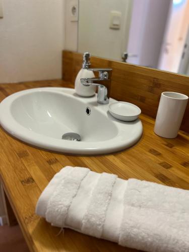 La salle de bains est pourvue d'un lavabo et d'une serviette sur un comptoir en bois. dans l'établissement Gîte Brin de Nature au cœur de la nature bugiste, à Ambérieu-en-Bugey