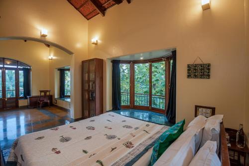 a large bedroom with a bed and a couch at SaffronStays Alma Grove, Kashid in Kashid