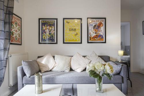 a living room with a couch and some framed posters at Comfortable apartment with terrace and garden - Welkeys in Bidart
