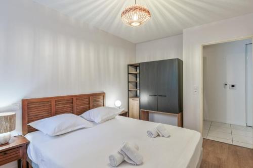 a bedroom with a large white bed and a cabinet at Appartement Delacroix - Welkeys in La Rochelle