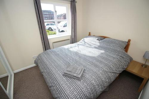 ein Schlafzimmer mit einem Bett und einem Handtuch darauf in der Unterkunft Modern 2 bed flat on marina development! in Saint Peters
