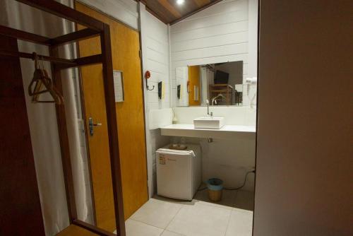 a bathroom with a sink and a toilet and a mirror at Pousada Fortaleza in Fernando de Noronha
