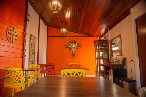 a dining room with a table and yellow chairs at Pousada Fortaleza in Fernando de Noronha