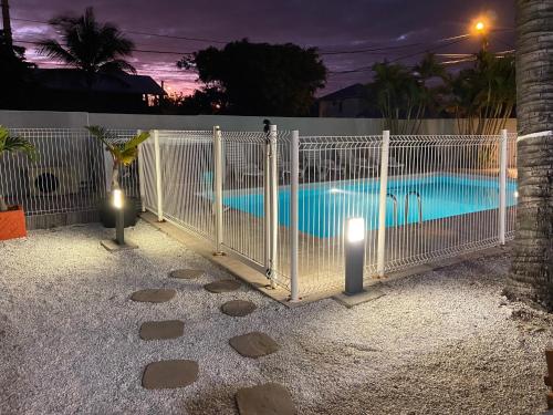 a gate leading to a swimming pool at night at LE NID TROPICAL in Étang-Salé les Bains