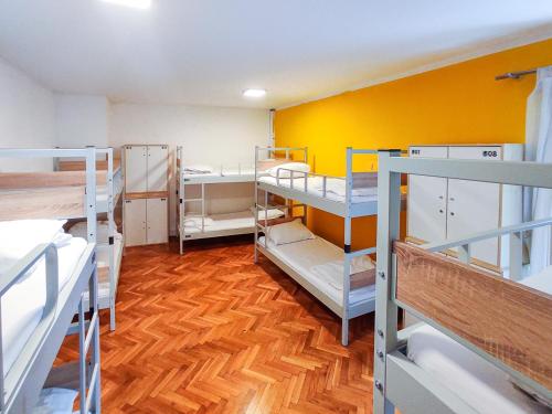 a room with several bunk beds and a yellow wall at Whole Wide World Hostel in Zagreb