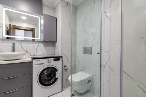 y baño con lavadora y lavamanos. en Sleek Residence Flat With Great Location in Sisli, en Estambul
