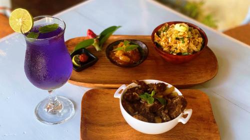 a table with two plates of food and a drink at LE JARDIN DU FORT - GALLE in Galle