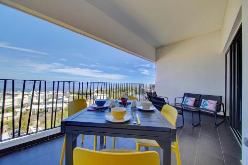 a dining room with a table and chairs on a balcony at L'appartement de l'Horizon - Plateau Cailloux in Fleurimont