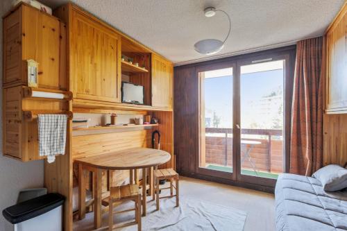 une petite cuisine avec une table et une fenêtre dans l'établissement Appartement des Bergers - Welkeys, à Huez