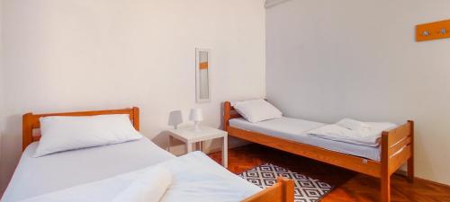 a small room with two beds and a night stand at Whole Wide World Hostel in Zagreb
