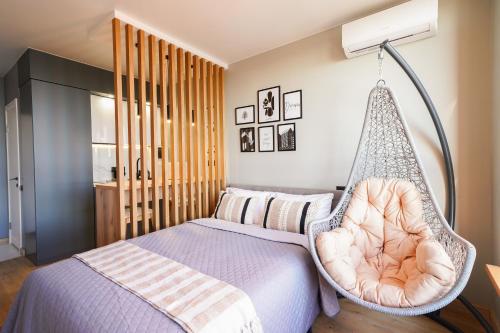 a bedroom with a bed with a swing at MYFREEDOM Апартаменти метро Почайна, Оболонь in Kyiv