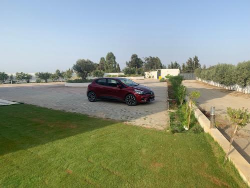 a red car parked in a parking lot at Maison des Oliviers, Yasmine Hammamet, Bouficha in Hammamet Sud