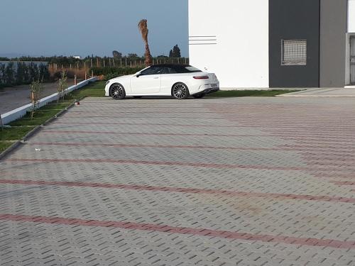 a white car parked in a parking lot at Maison des Oliviers, Yasmine Hammamet, Bouficha in Hammamet Sud