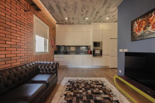a living room with a couch and a brick wall at Caju Deluxe Apartment in Aveiro