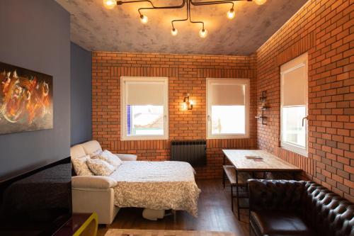 a bedroom with a bed and a brick wall at Caju Deluxe Apartment in Aveiro