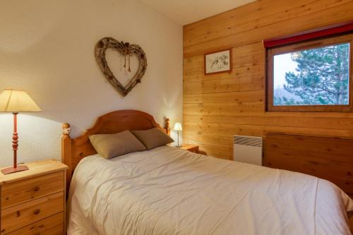 a bedroom with a bed and a heart shaped mirror at Les Dolomites en Trièves in Gresse-en-Vercors
