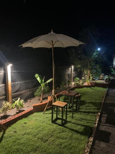 a table and an umbrella in a yard at night at Villafarmsuk@khanom in Khanom