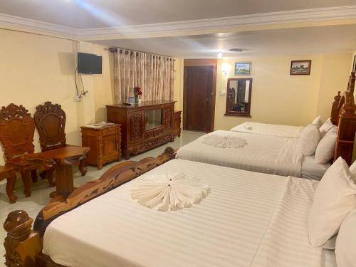 a hotel room with two beds and a television at Savet Guesthouse in Stœ̆ng Trêng