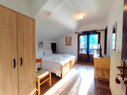 a bedroom with a bed and a large window at Hotel TEA Dolomiti in Alleghe