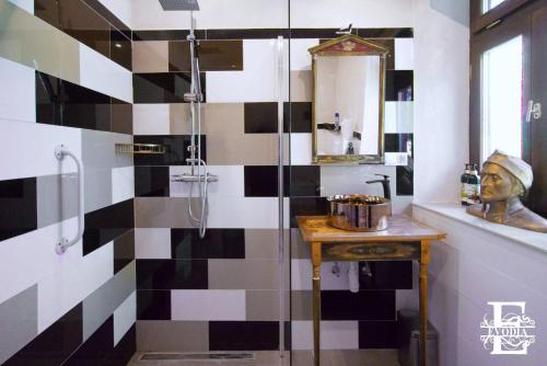 a bathroom with a black and white tiled wall at Patrimonium Wellness Apartments in Tiszaszentimre
