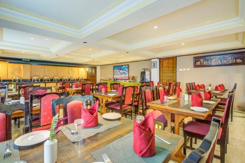 ペリングにあるSummit Tashi Ghang Heritage Resortのテーブル、椅子、赤い椅子が備わるレストラン