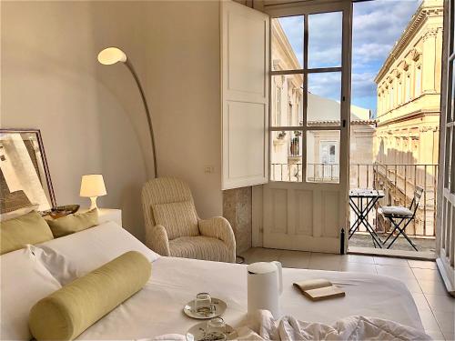 um quarto com uma cama e uma grande janela em Maestranza72 by Bed&Bros em Siracusa