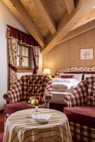 a hotel room with a bed and a table and chairs at Hotel Chalet Del Sogno in Madonna di Campiglio