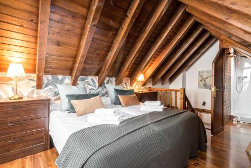 un grande letto in una camera con soffitti in legno di Tanau 1700 by SeaMount Rentals a Naut Aran