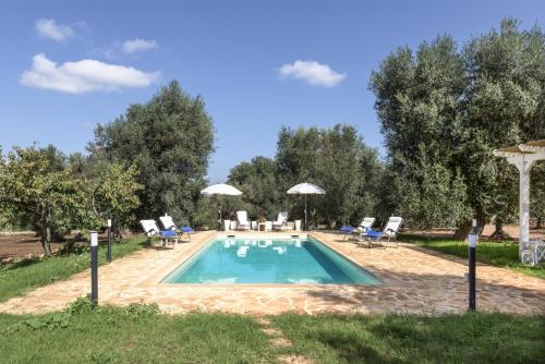 einen Pool mit Stühlen und Sonnenschirmen im Hof in der Unterkunft le dimore di MaMa in Ceglie Messapica