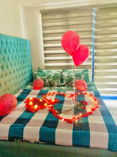 a bed with red balloons and decorations on it at Sea Residences Tower F Angel in Manila