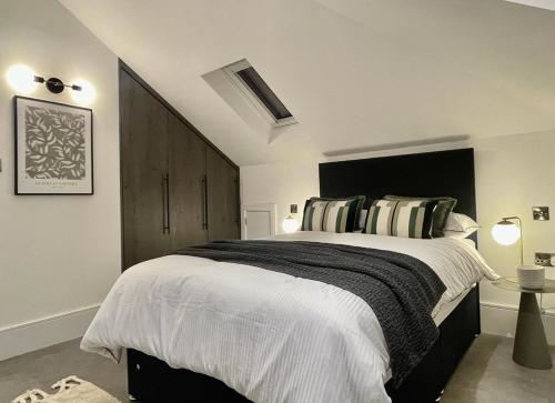 a bedroom with a large bed with a black headboard at 2 Bedroom Penthouse Apartment in London