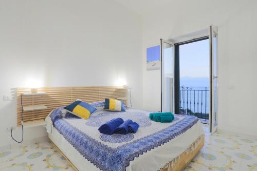 - une chambre avec un grand lit et des serviettes bleues dans l'établissement Amazing Seaview Apartment with garden, à Vietri