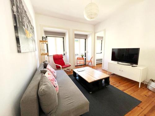a living room with a couch and a flat screen tv at Tram House @ Lx Factory! in Lisbon