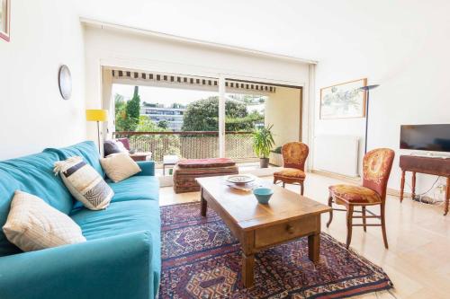 un salon avec un canapé bleu et une table dans l'établissement Le Gallia haven of peace in the city center with Terrace GALLIA LYS, à Cannes