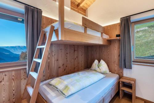 ein Etagenbett in einem winzigen Haus mit einer Leiter in der Unterkunft Guntschöllerhof Mendelkamm in Völs am Schlern