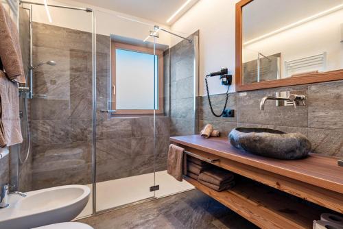 uma casa de banho com uma cabina de duche em vidro e um lavatório. em Guntschöllerhof Mendelkamm em Fiè