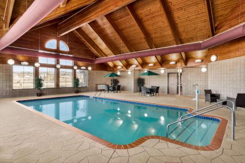 a swimming pool in a building with a wooden ceiling at AmericInn by Wyndham Laramie Near University of Wyoming in Laramie