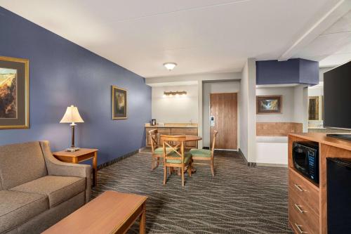 a living room with a couch and a table at AmericInn by Wyndham Laramie Near University of Wyoming in Laramie