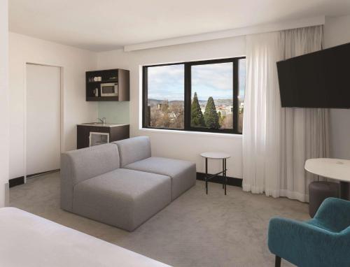 a living room with a couch and a large window at Travelodge Hotel Hobart in Hobart